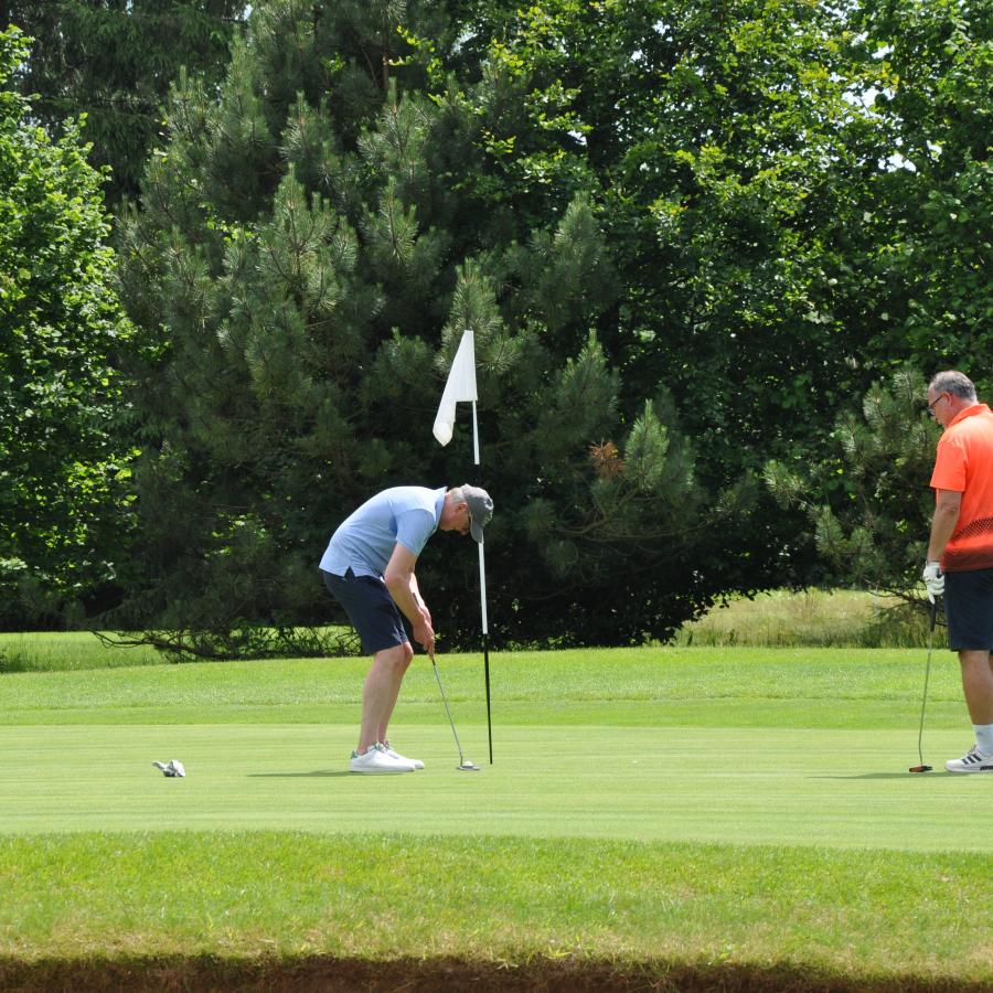 Zwei Menschen stehen vor einem Golfloch