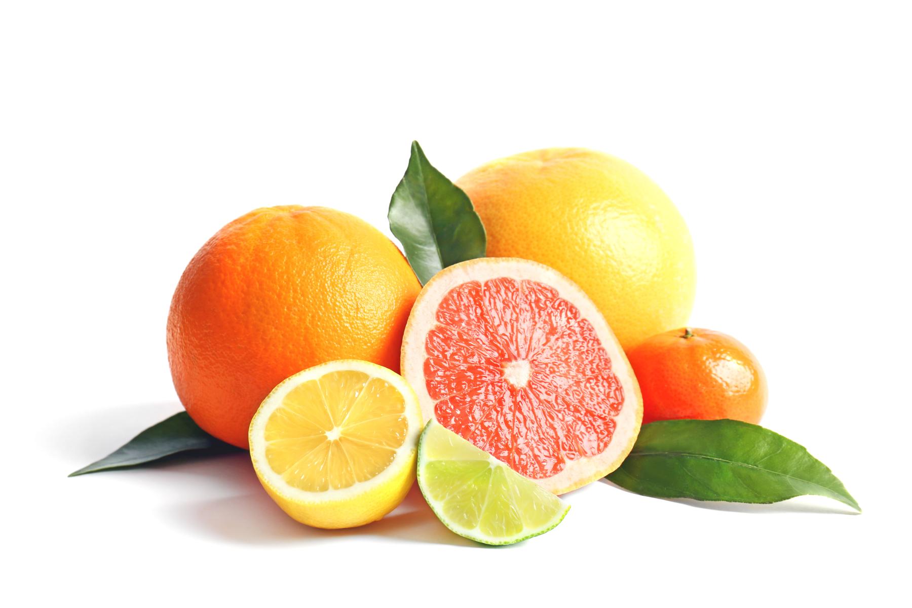 Verschiedene Citrusfrüchte mit Blättern, darunter Orange, Grapefruit, Zitrone und Limette, einige halbiert