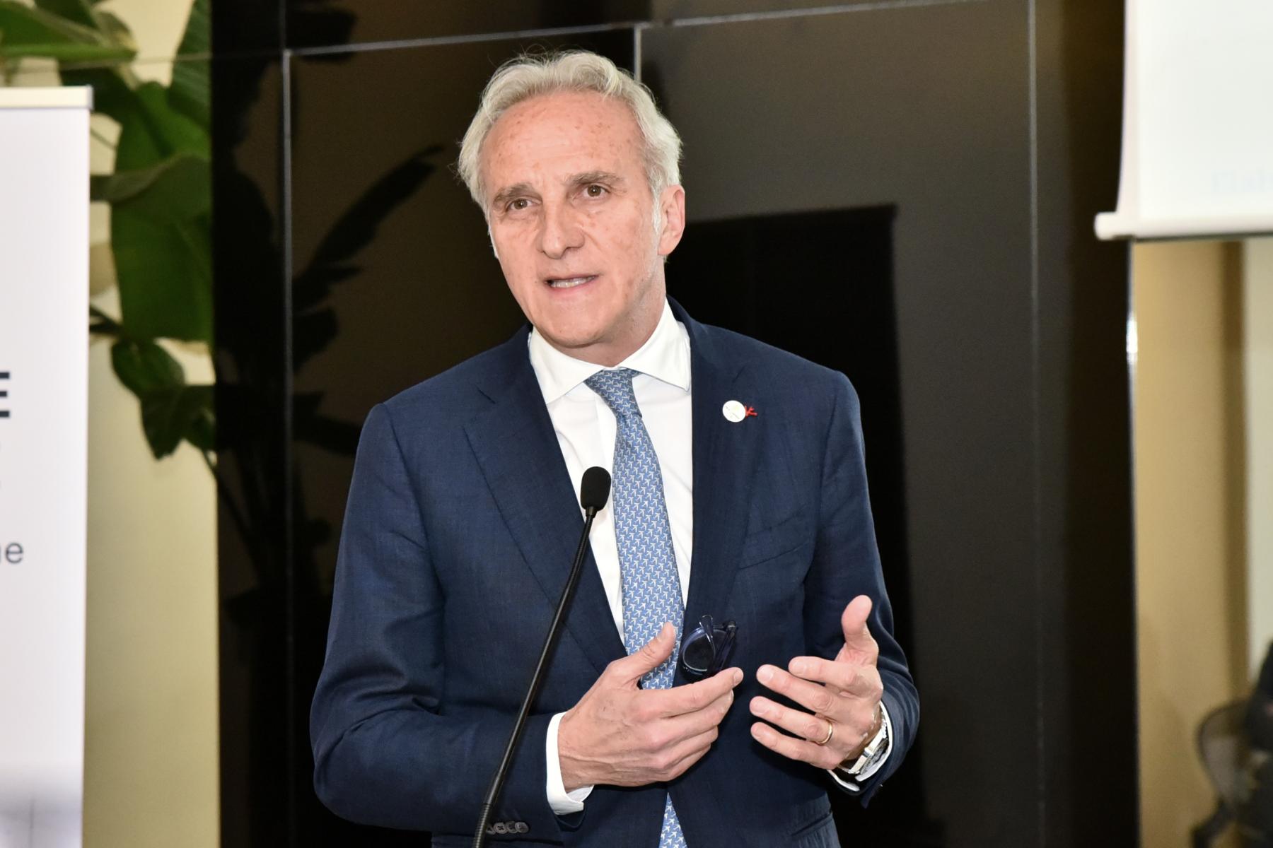 Fruitimprese-Präsident Marco Salvi spricht stehend vor Mikrofon, trägt blauen Anzug und hellblaue Krawatte