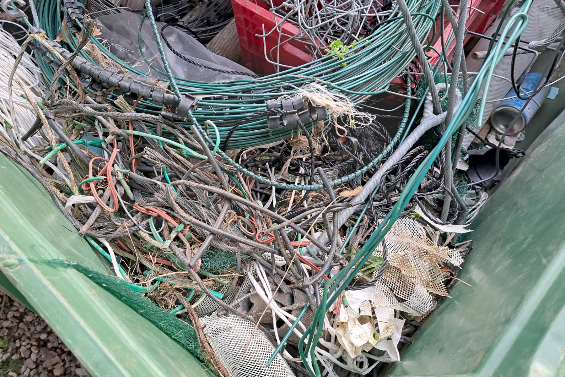 Kunststoff-Abfall in der Landwirtschaft, darunter Kabel, Netze und Plastikreste in einem Sammelbehälter