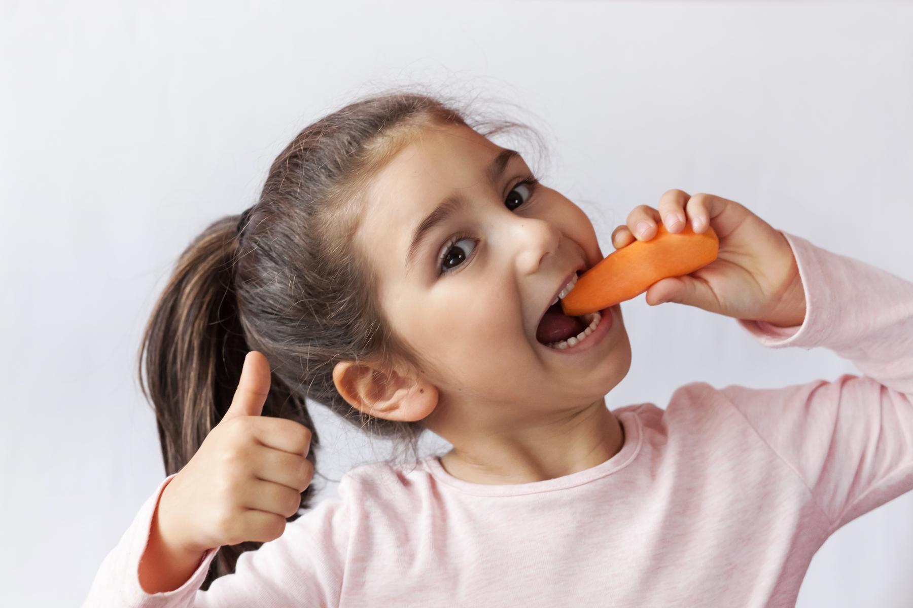 Mädchen isst Möhre