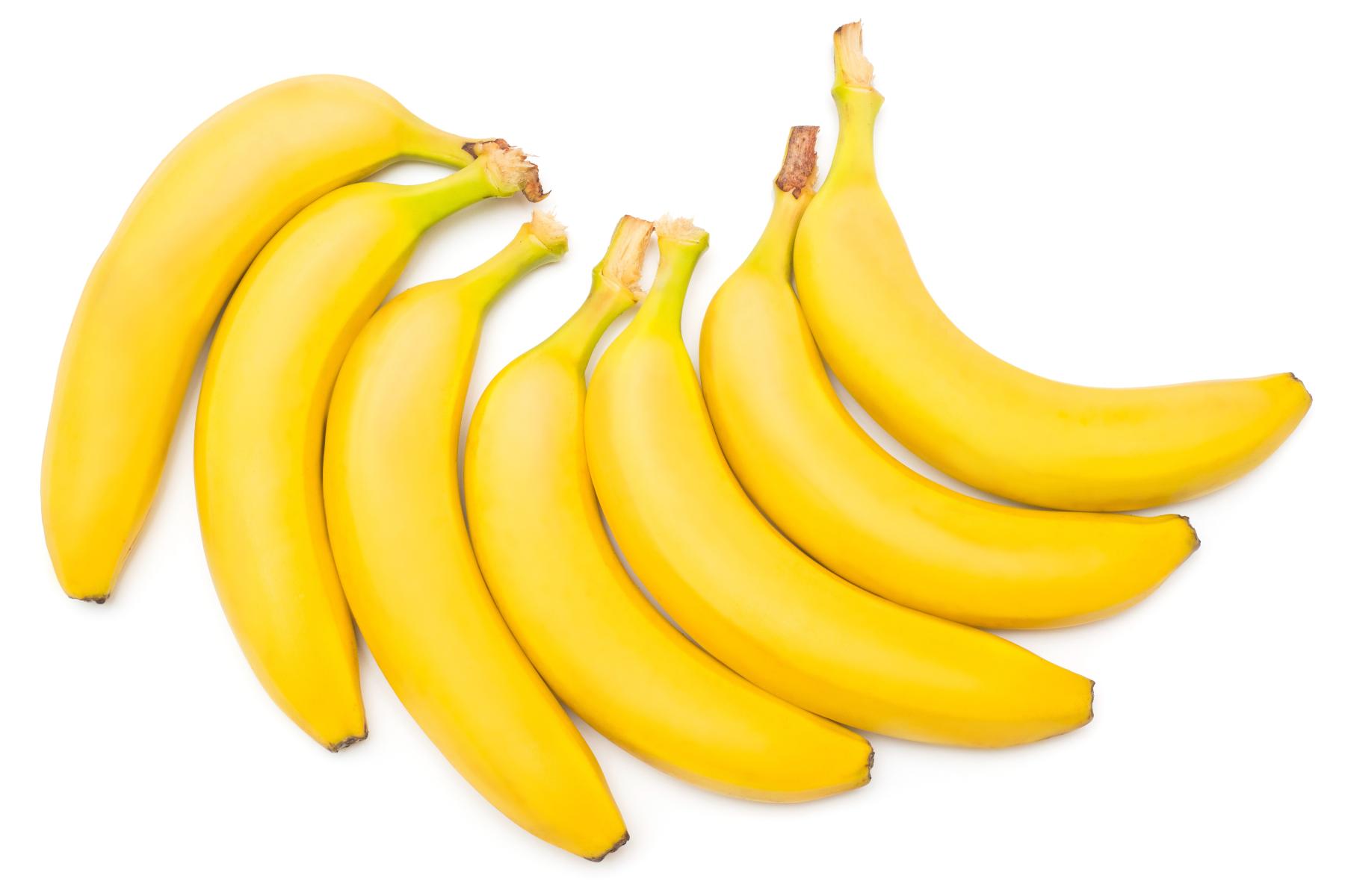 Sieben gelbe Bananen mit Stielansatz, angeordnet auf weißem Hintergrund