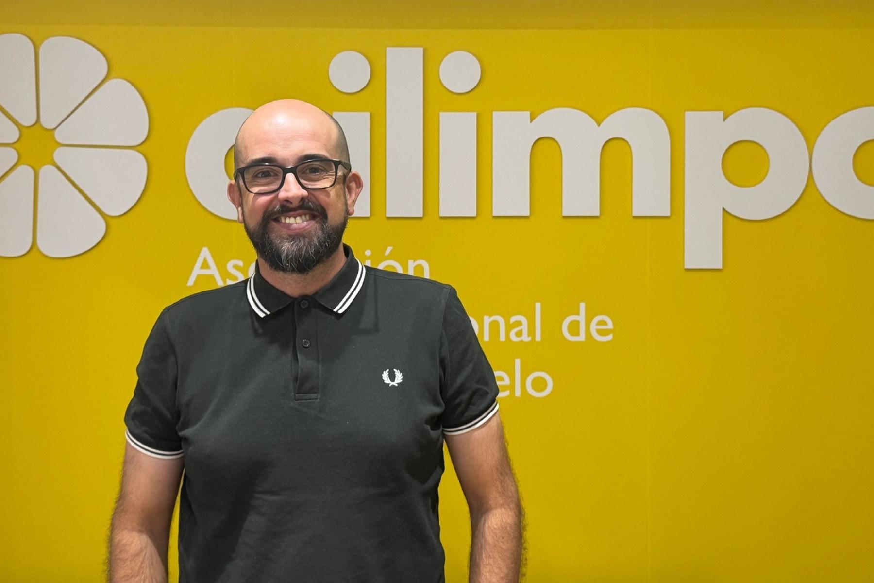 Joaquin Rubio Gomaríz steht vor gelber Wand mit weißem Ailimpo Logo
