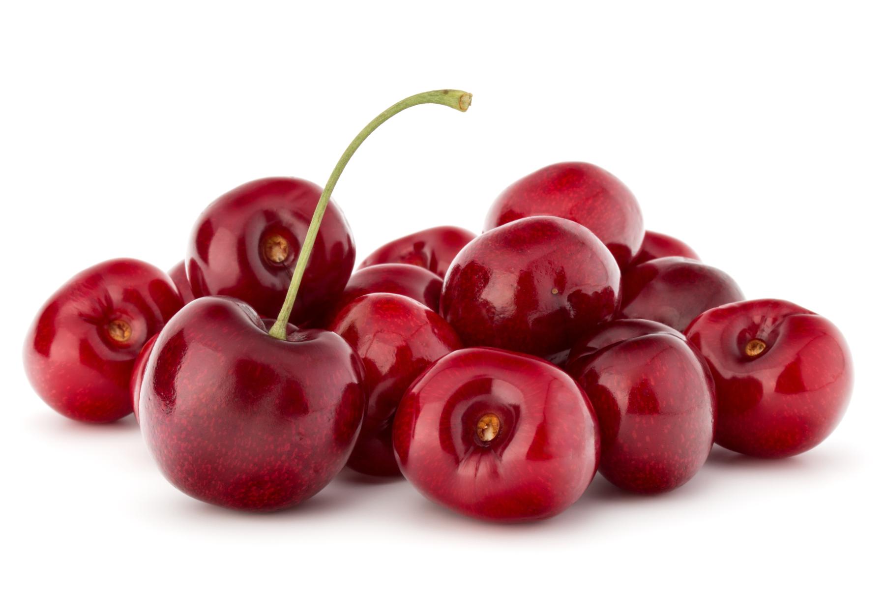 Mehrere rote Kirschen, eine mit grünem Stiel, auf weißem Hintergrund
