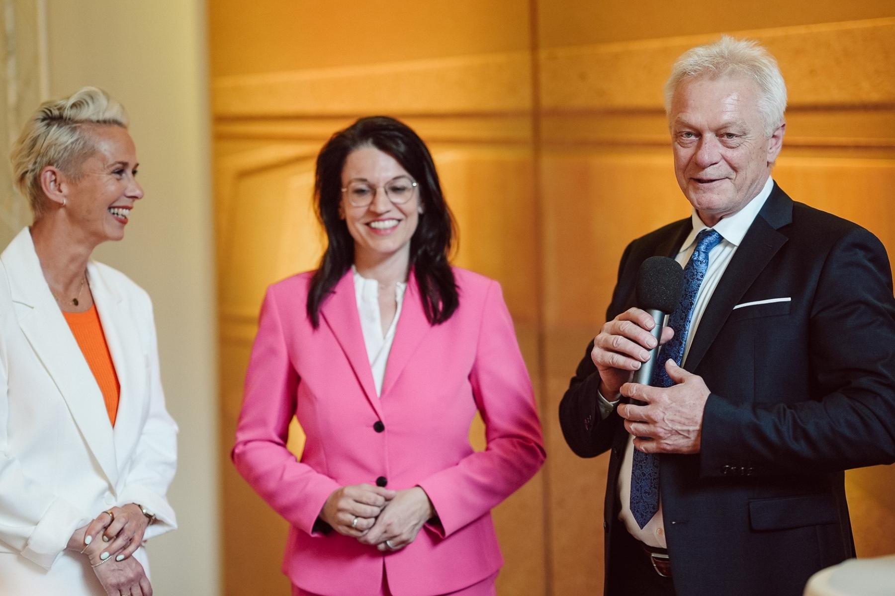 Alois Rainer mit Mikrofon, Silvia Breher, Martina Englhardt-Kopf, stehend vor goldfarbenem Hintergrund