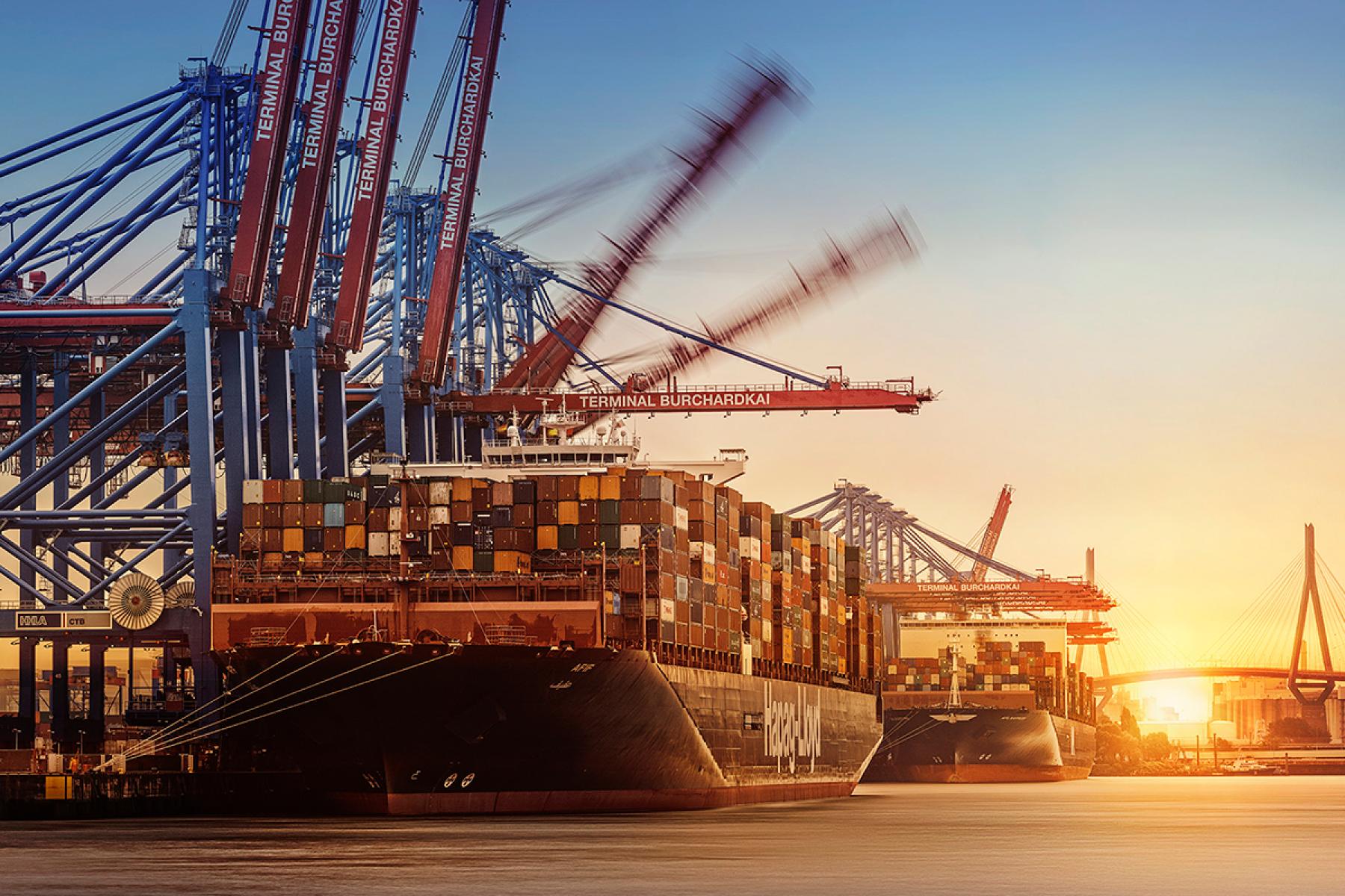 Containerschiff Afif im Hamburger Hafen beladen mit Containern unter Kränen bei Sonnenuntergang