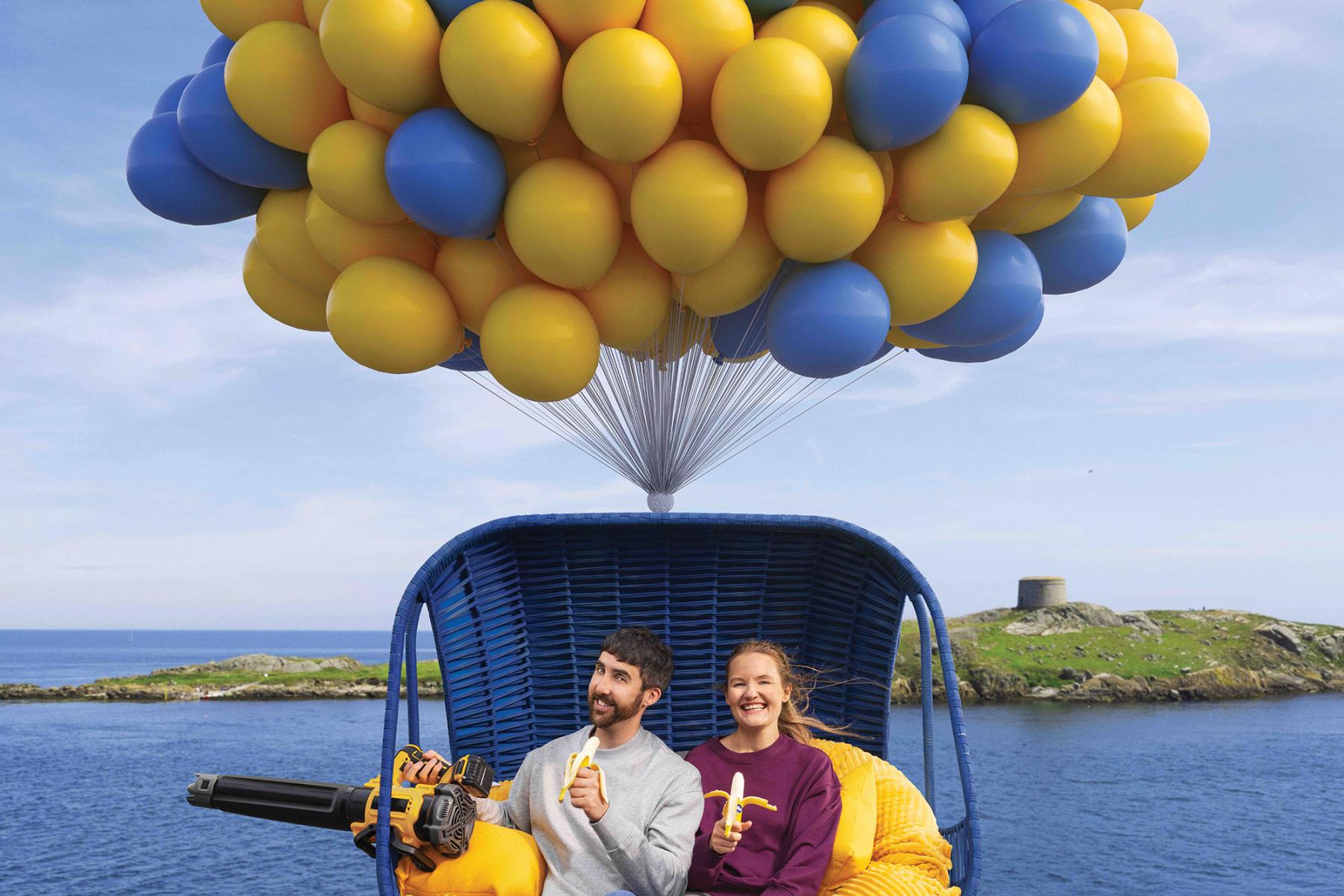 Mann und Frau in einem Korb, der von Ballons getragen wird