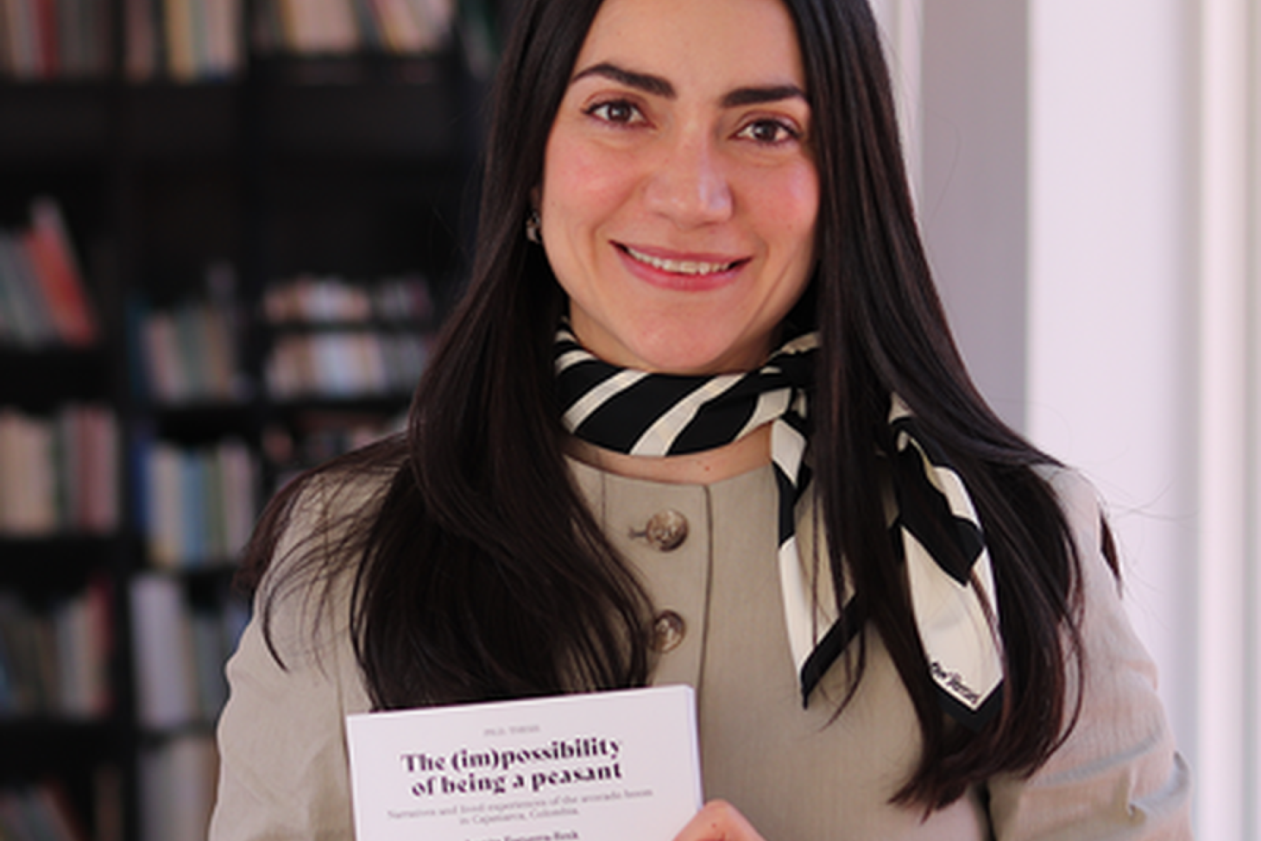 Juanita Esguerra Rezk hält ein Buch mit dem Titel 'The (im)possibility of being a peasant',
