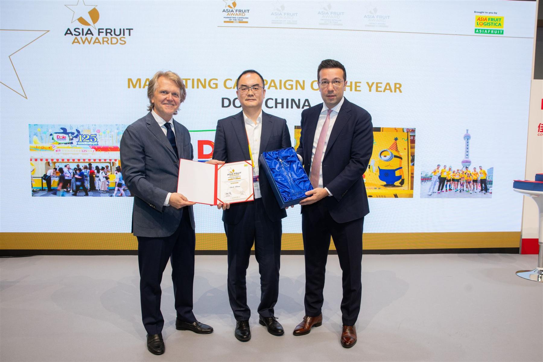 Leo Li in der Mitte erhält den Award von Chris White links und David Axiotis rechts. Im Hintergrund steht 'ASIA FRUIT AWARDS' und 'MARKETING CAMPAIGN OF THE YEAR DOLE CHINA'.