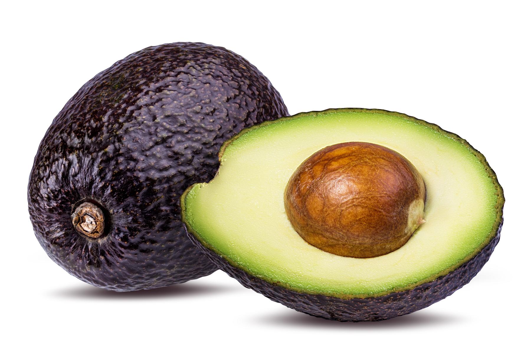 eine ganze und eine halbe Avocado, bei der halben ist sowohl Fruchtfleisch, als auch der Kern sichtbar