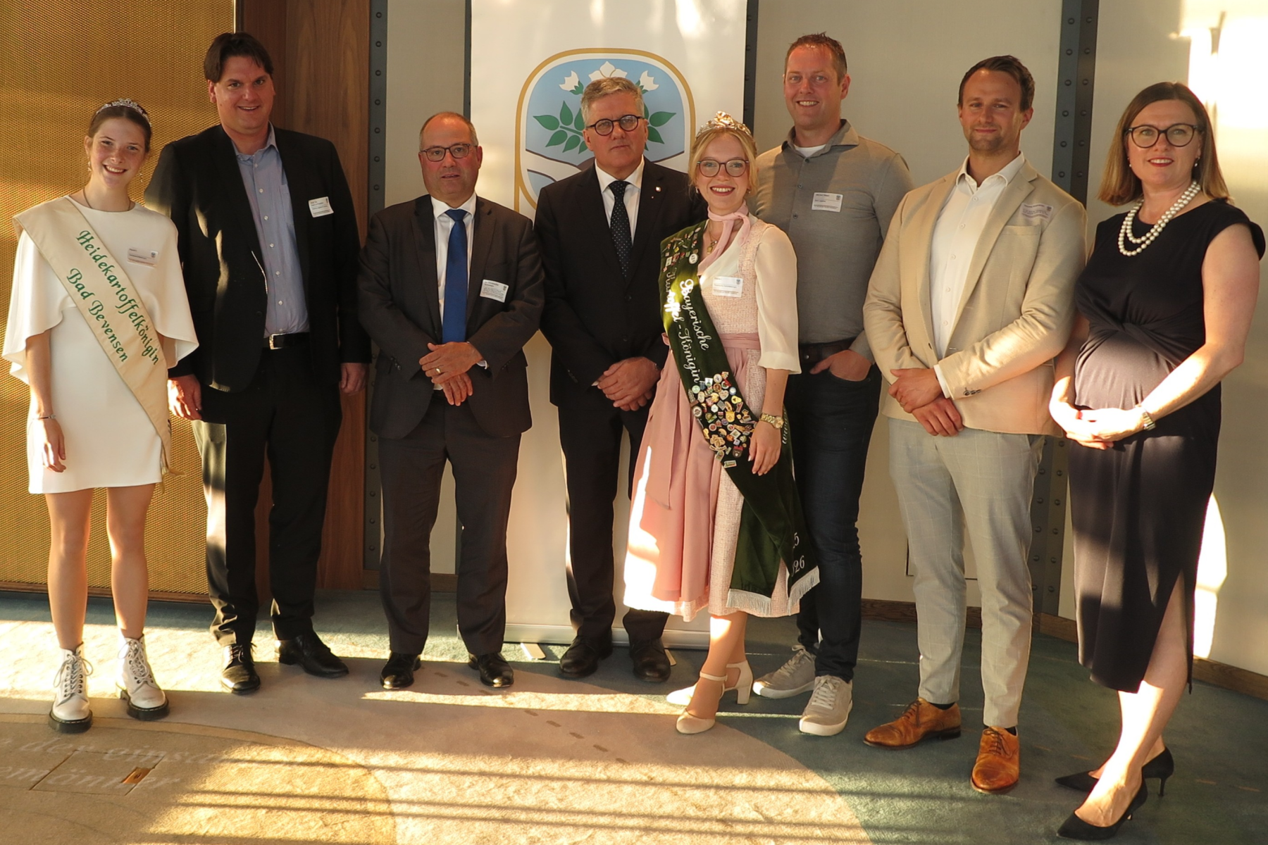 Gruppenfoto v.l.: Heidekartoffelkönigin Paula I, Prof. Dr. Hanno Friedrich, Dr. Christopher Schwieger, Thomas Herkenrath, Bayrische Kartoffelkönigin Elena I, Wiechert Steert, Sascha Rosenblatt, Jutta Becker-Ritterspach. Zwei Frauen tragen Schärpen, alle sind formell gekleidet.