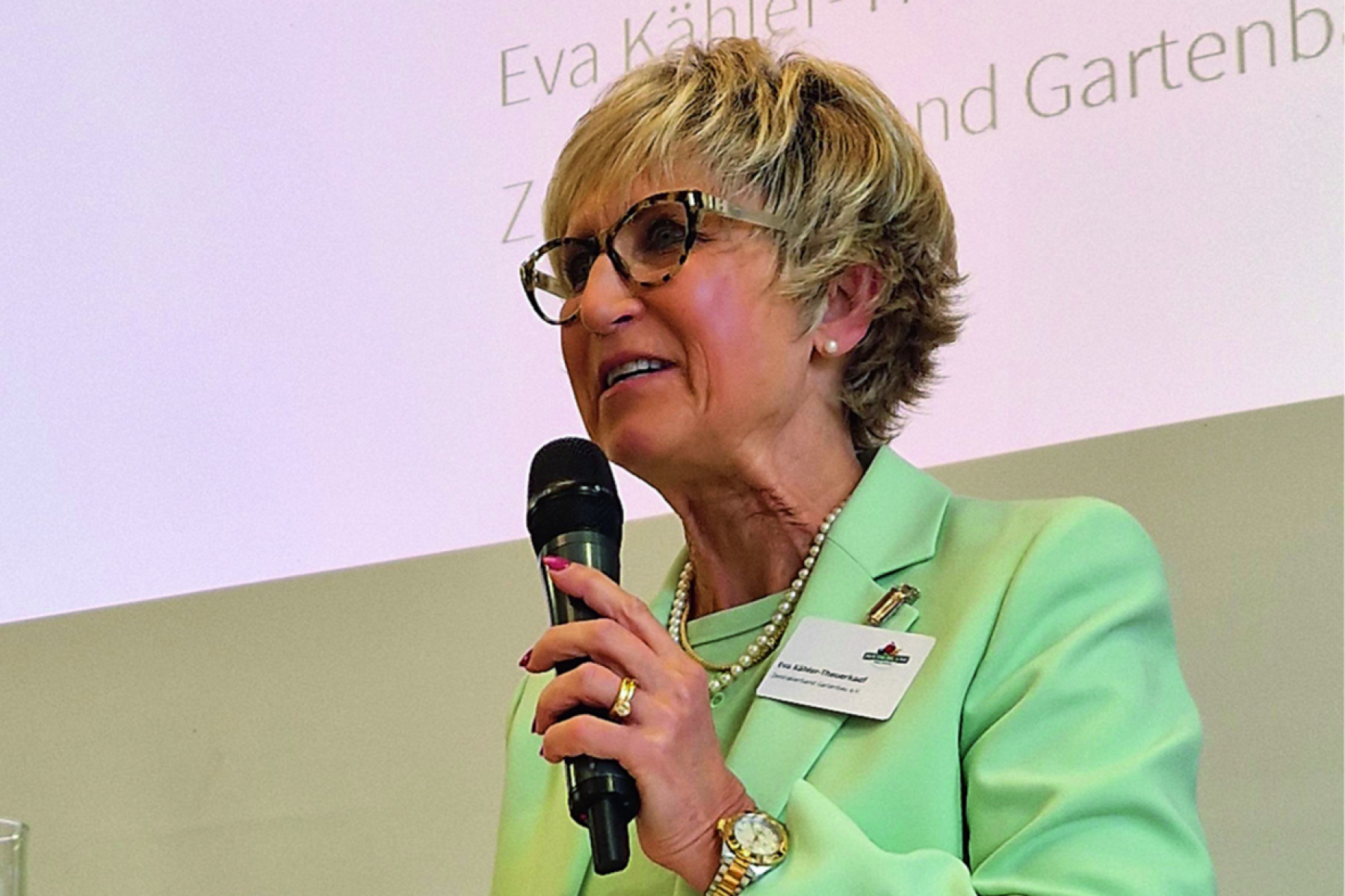 Eva Kähler-Theuerkauf hält eine Präsentation und spricht dabei in ein Mikro.