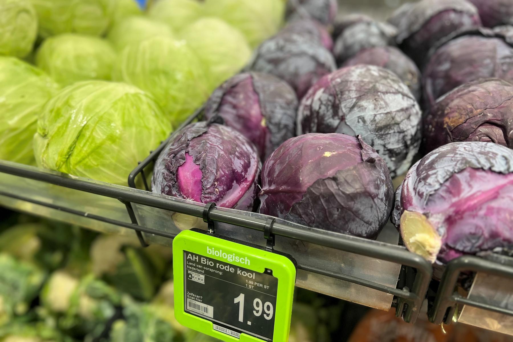 Regal mit grünem und rotem Bio-Kohl, Preisschild 1,99 Euro im Supermarkt.