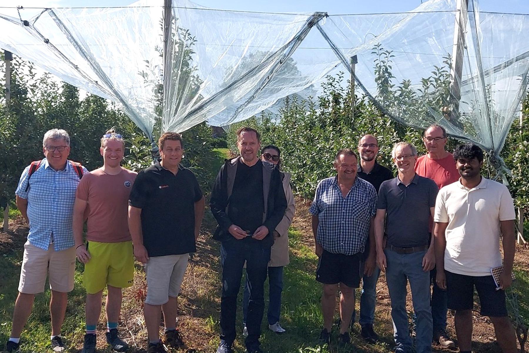 Zehn am Projekt beteiligte Personen vor einer Apfelplantage. Ihre Namen sind: Markus Mayer (IWT), Peter Buckel (DHBW), Matthias Strobel (inMach), Hans Riepe-Gedon und Fatma Mawla (gedonsoft), Hubert Bernhard (Osthof Bernhard), Manuel Wopfner (gedonsoft), Thomas Dietmüller (DHBW), Andreas Mahler (inMach), Pranav Tej Gangavarapu (DHBW)