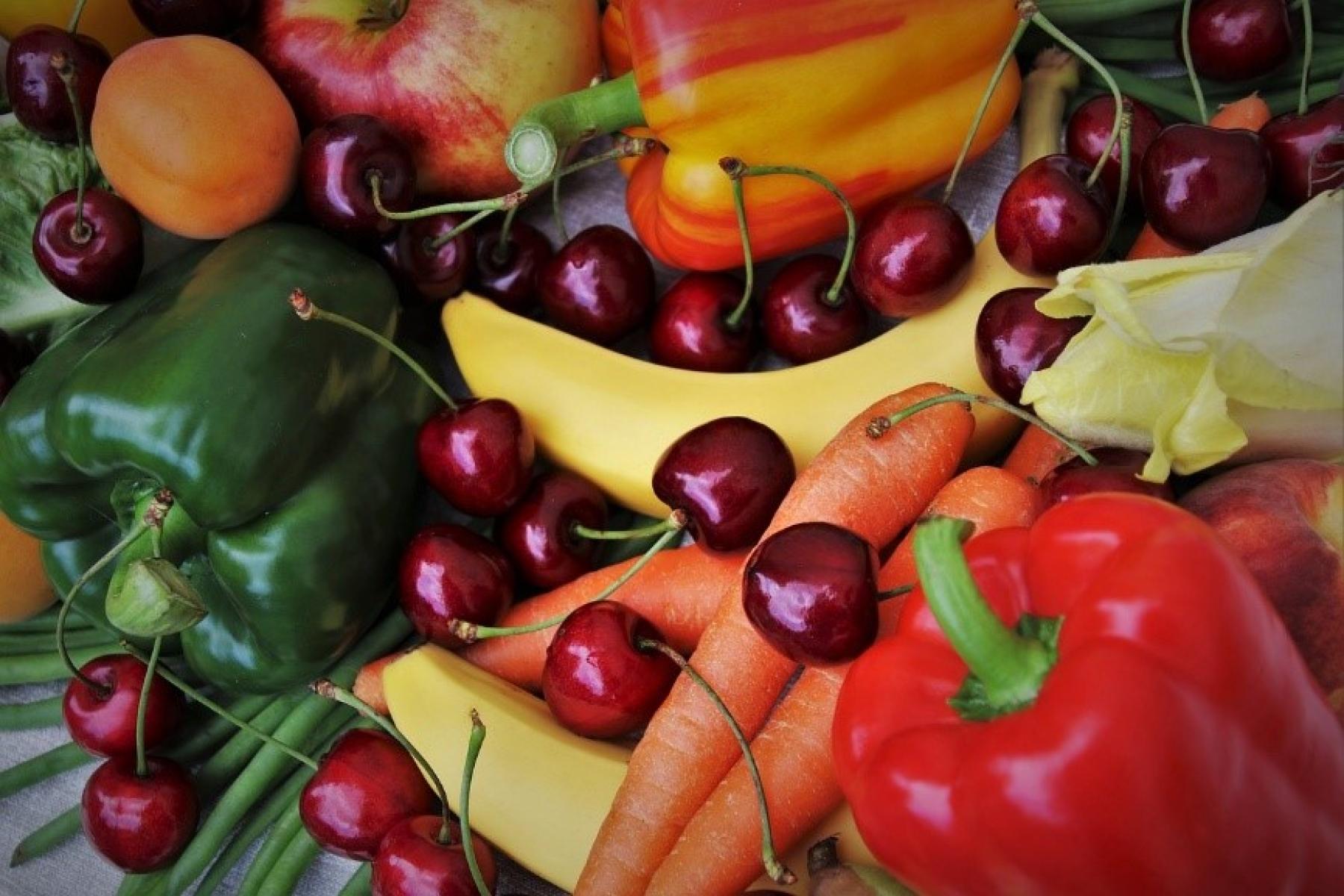 Nahaufnahme von roten und grünen Paprikaschoten, Bananen, Karotten, Kirschen und Aprikosen