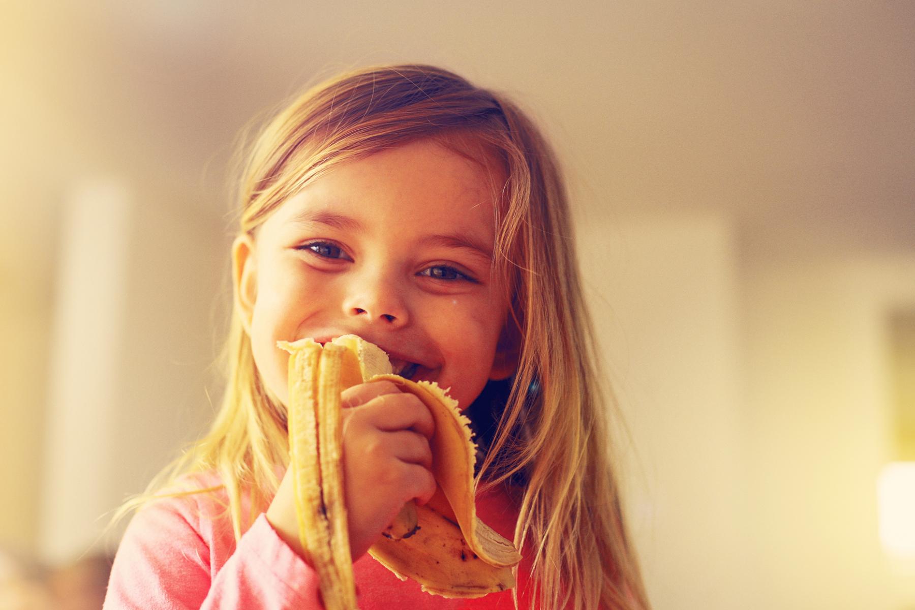 blondes Mädchen isst Banane