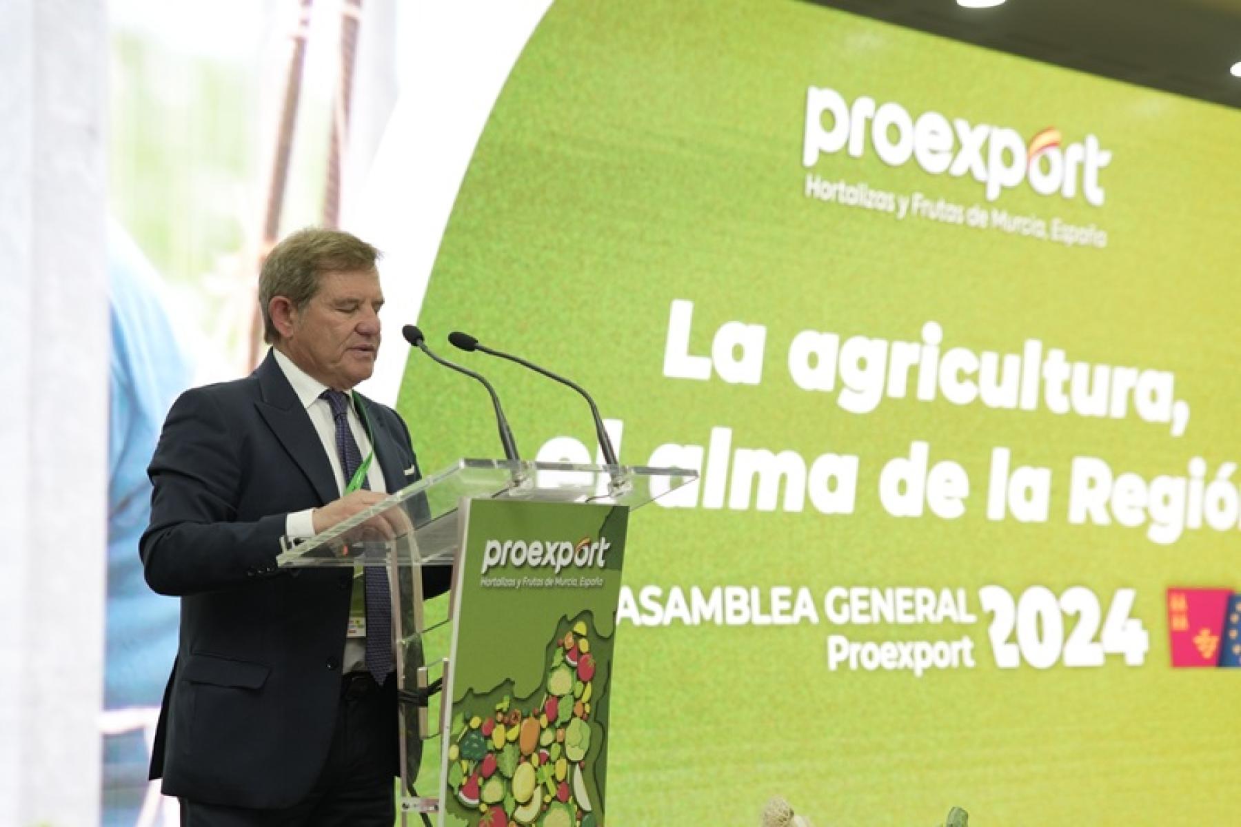 Mariano Zapata steht am Rednerpult mit Mikrofonen, im Hintergrund eine grün-gelbe Präsentationswand mit dem Text 'proexport', 'La agricultura, el alma de la Región', 'ASAMBLEA GENERAL Proexport 2024'.