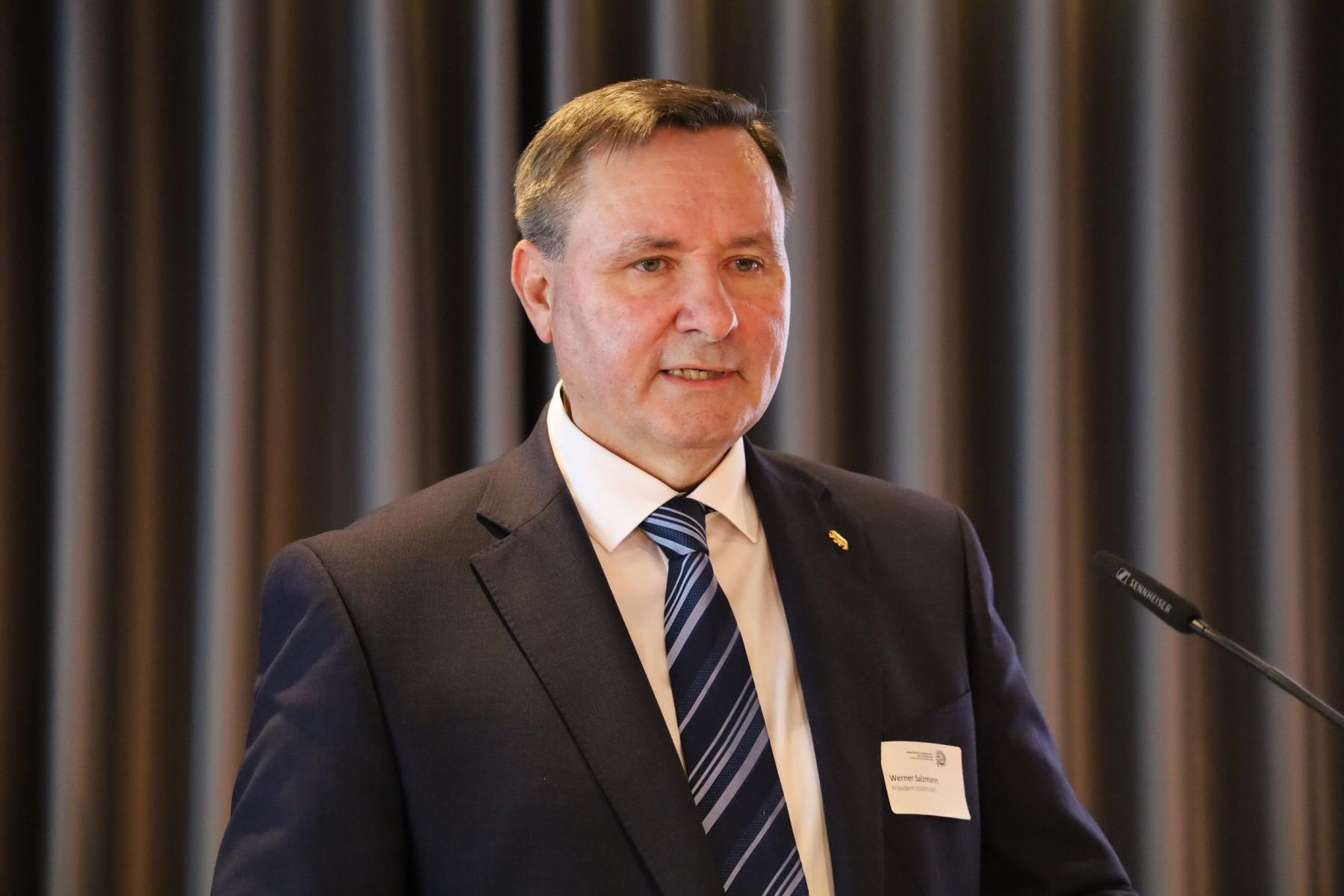 Werner Salzmann steht an einem Rednerpult mit Mikro