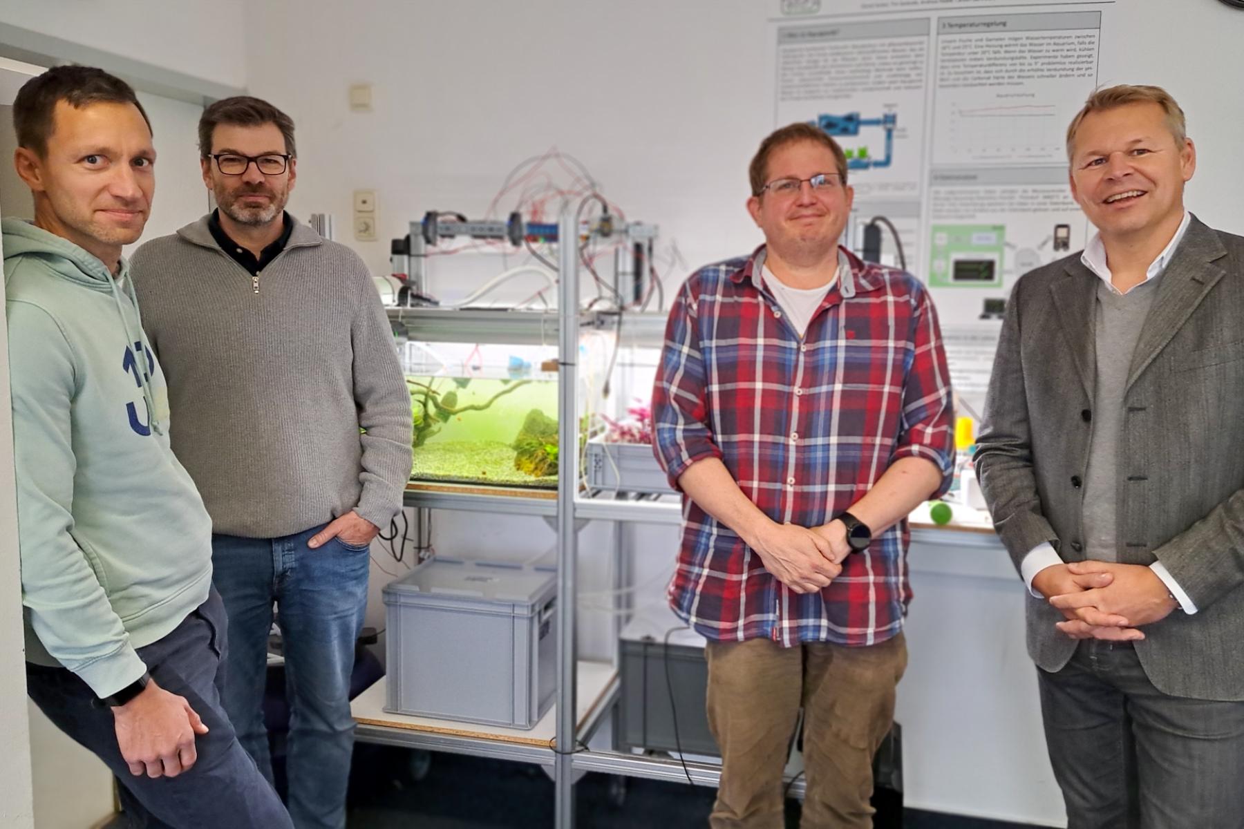 Prof. Jan-Paul Lüdtke, Prof. Carsten Burmeister, Christian Krug (Projektinitiatoren) und Prof. Eike Harms (Hochschulpräsident) (v.l.) präsentieren die Aquaponik-Anlage im Industrie 4.0-Labor der Fachhochschule Wedel.
