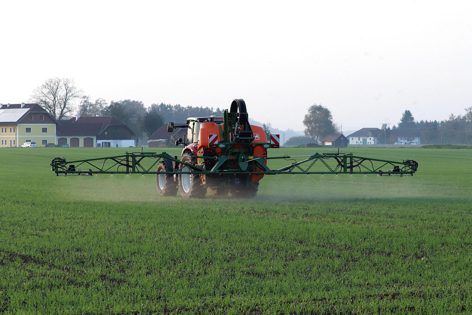 Traktor verteilt Pflanzenschutzmittel auf dem Feld