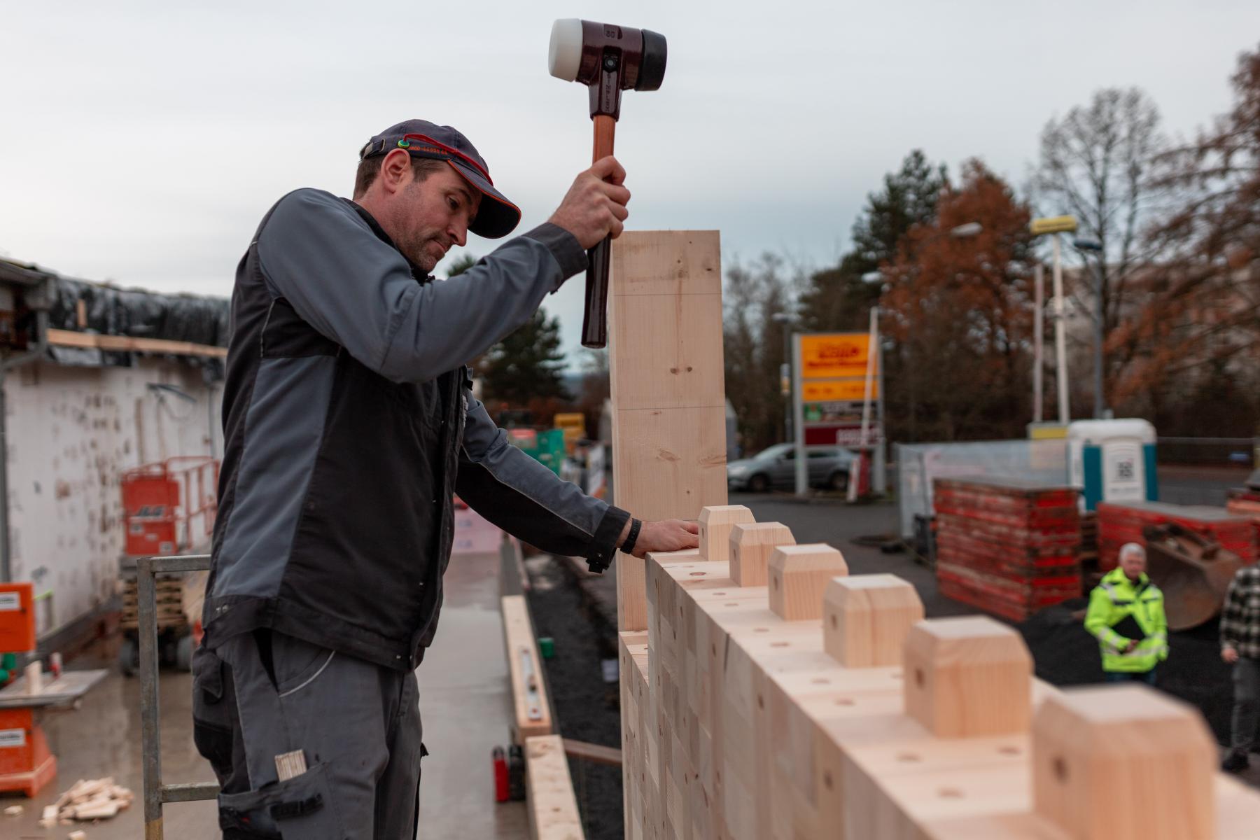 Arbeiter baut Holzfiliale