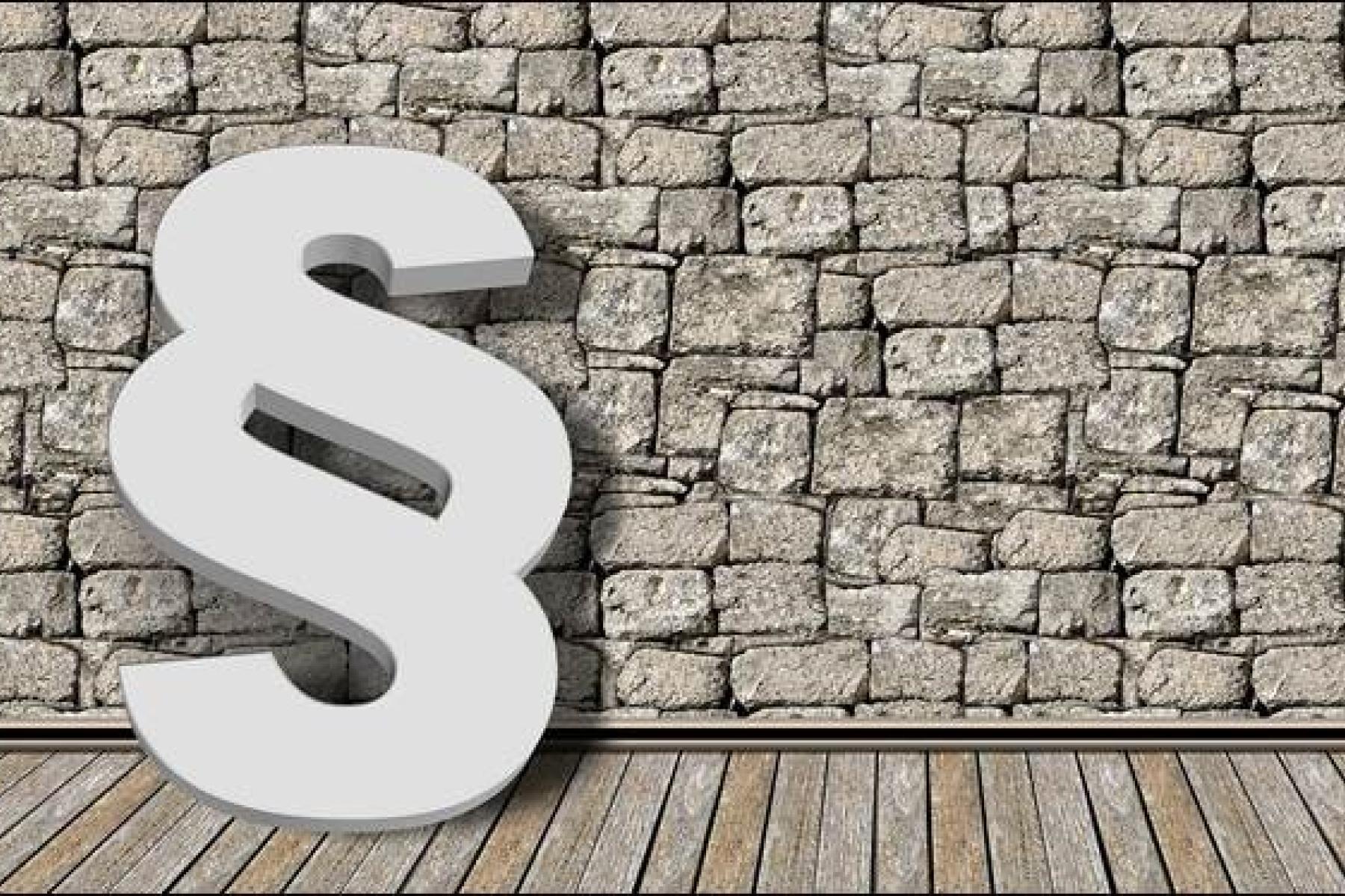 Paragraf-Symbol vor Mauer