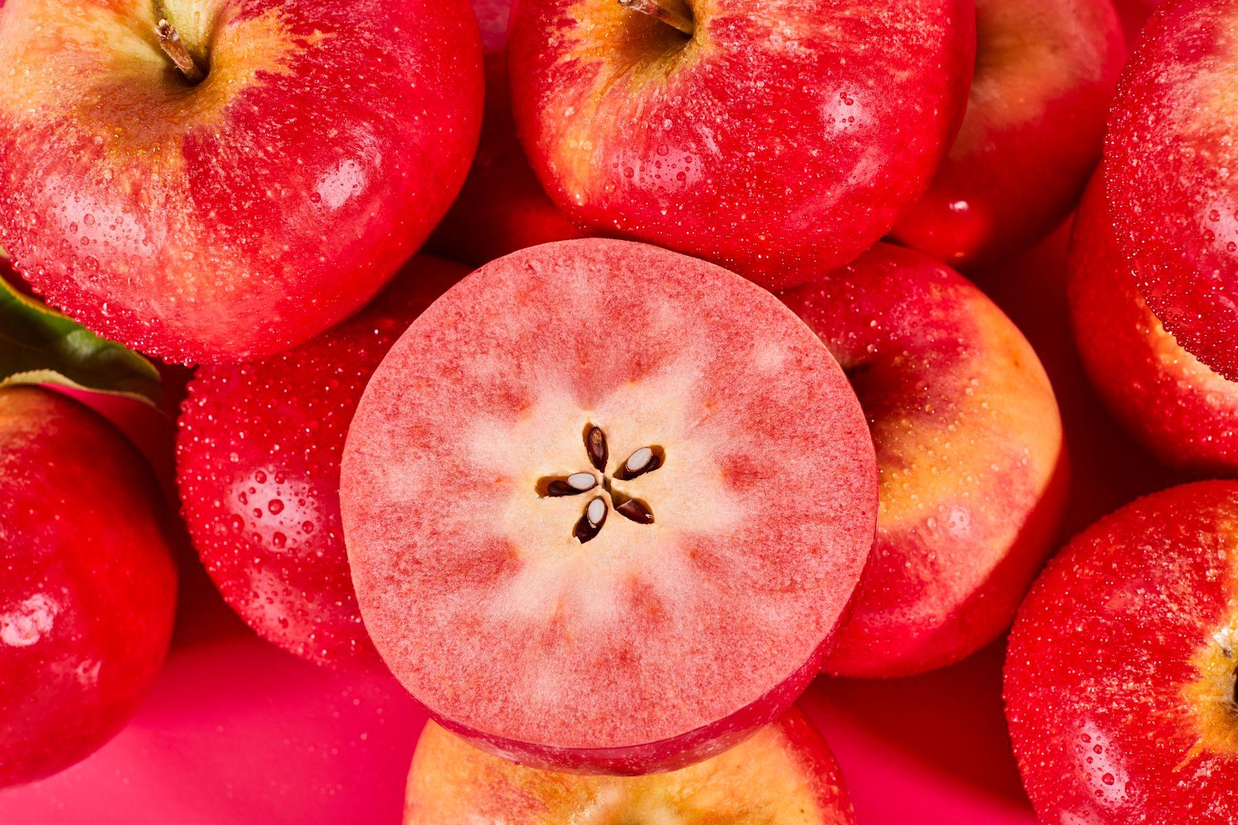 halbierter und ganzer rotfleischiger Apfel Fizz