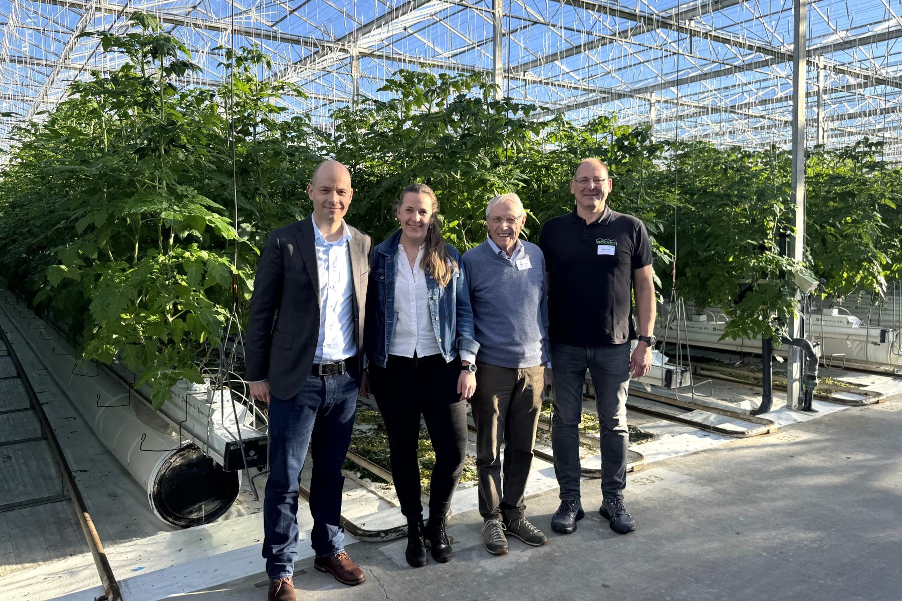 In einem Gewächshaus stehen folgende Personen: Matija Nuic, Direktor des VSGP, GVBF-Präsidentin Katja Riem, VSGP-Altdirektor Fredi Schwab und Produzent Beat Bösiger