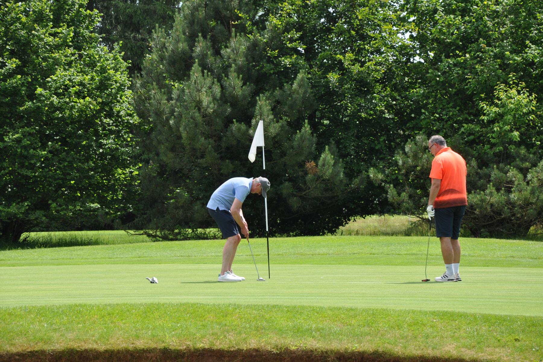 Zwei Menschen stehen vor einem Golfloch