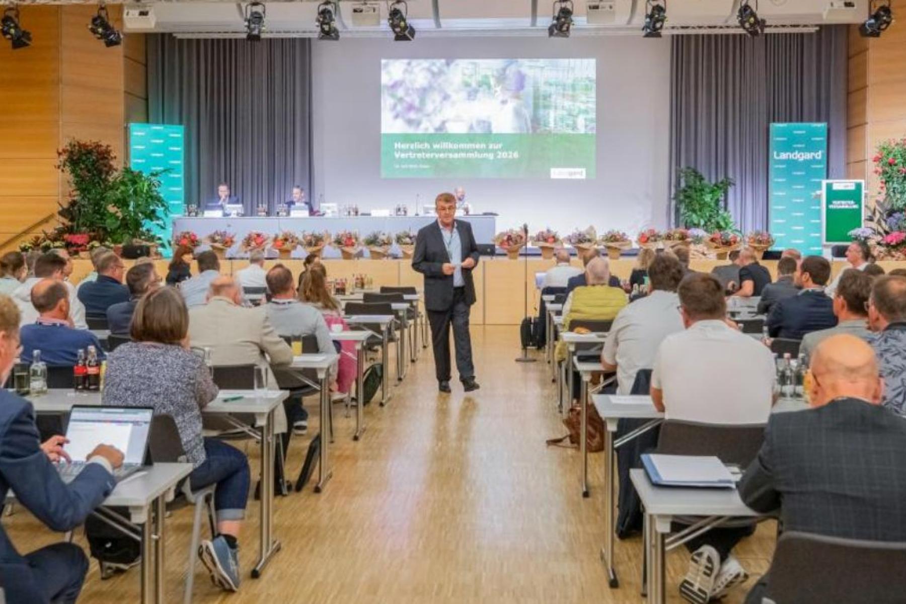 Menschen sitzen in Vortragsraum und schauen auf Folien an der Wand