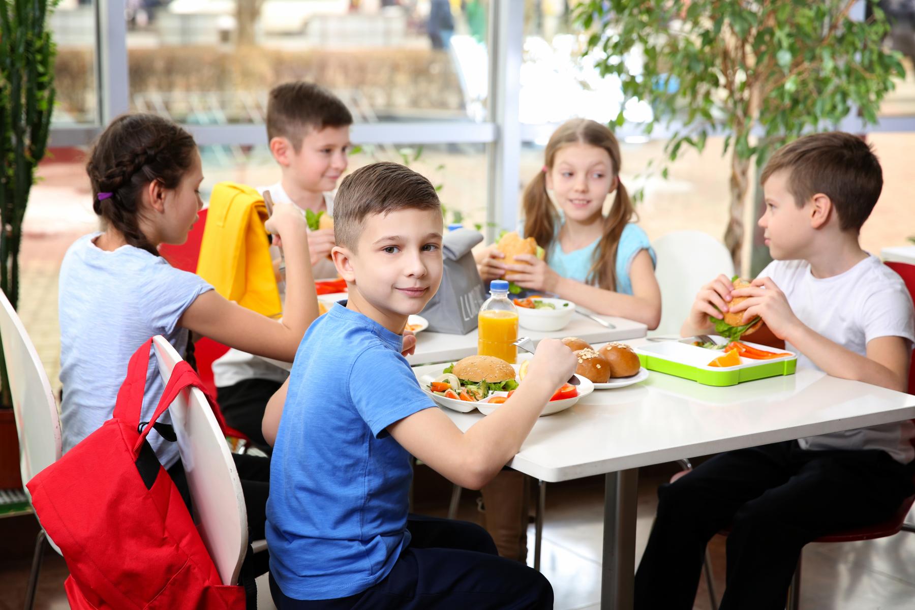 Kinder sitzen mit Essen am Tisch