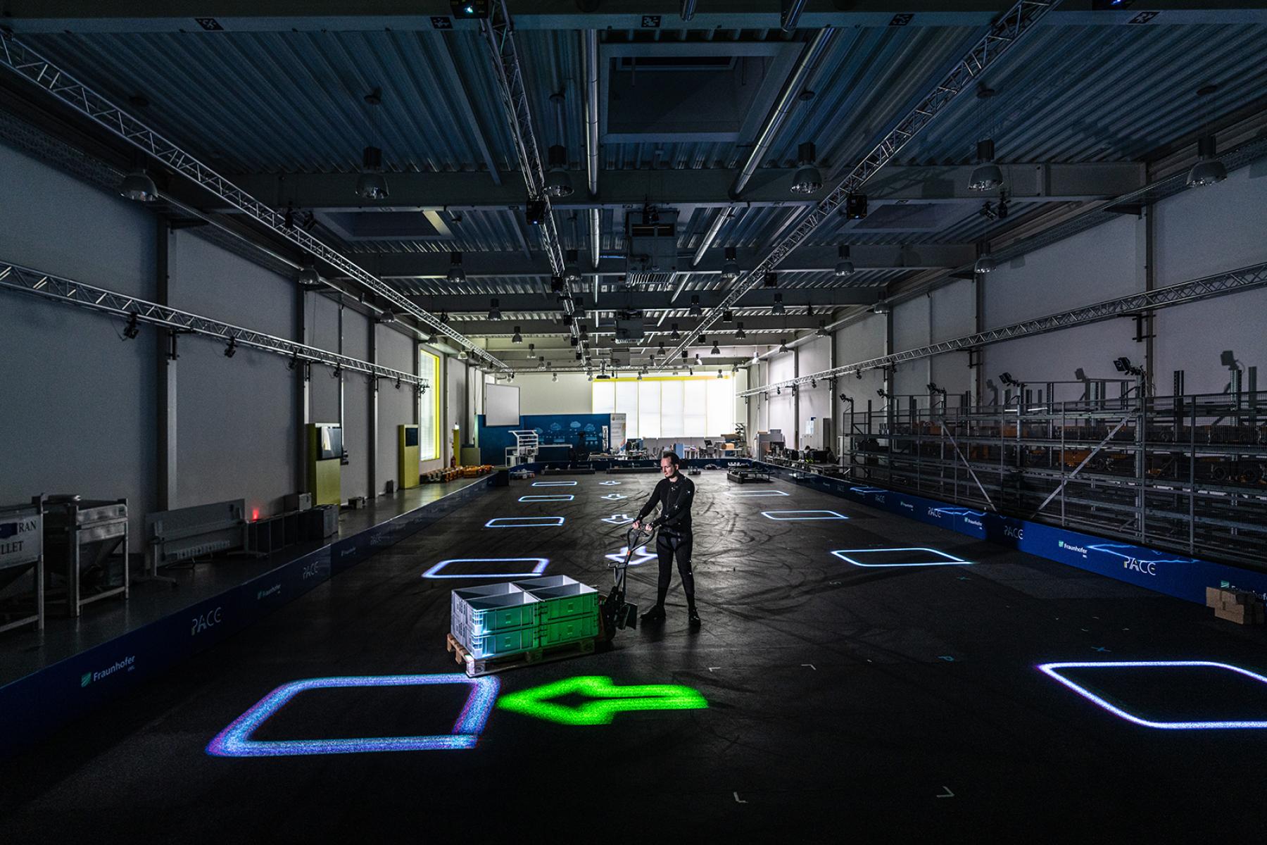 Blick auf Lagerhalle mit dynamischem Leitsystem LARS und Laserprojektion direkt auf dem Boden der Lagerhalle.
