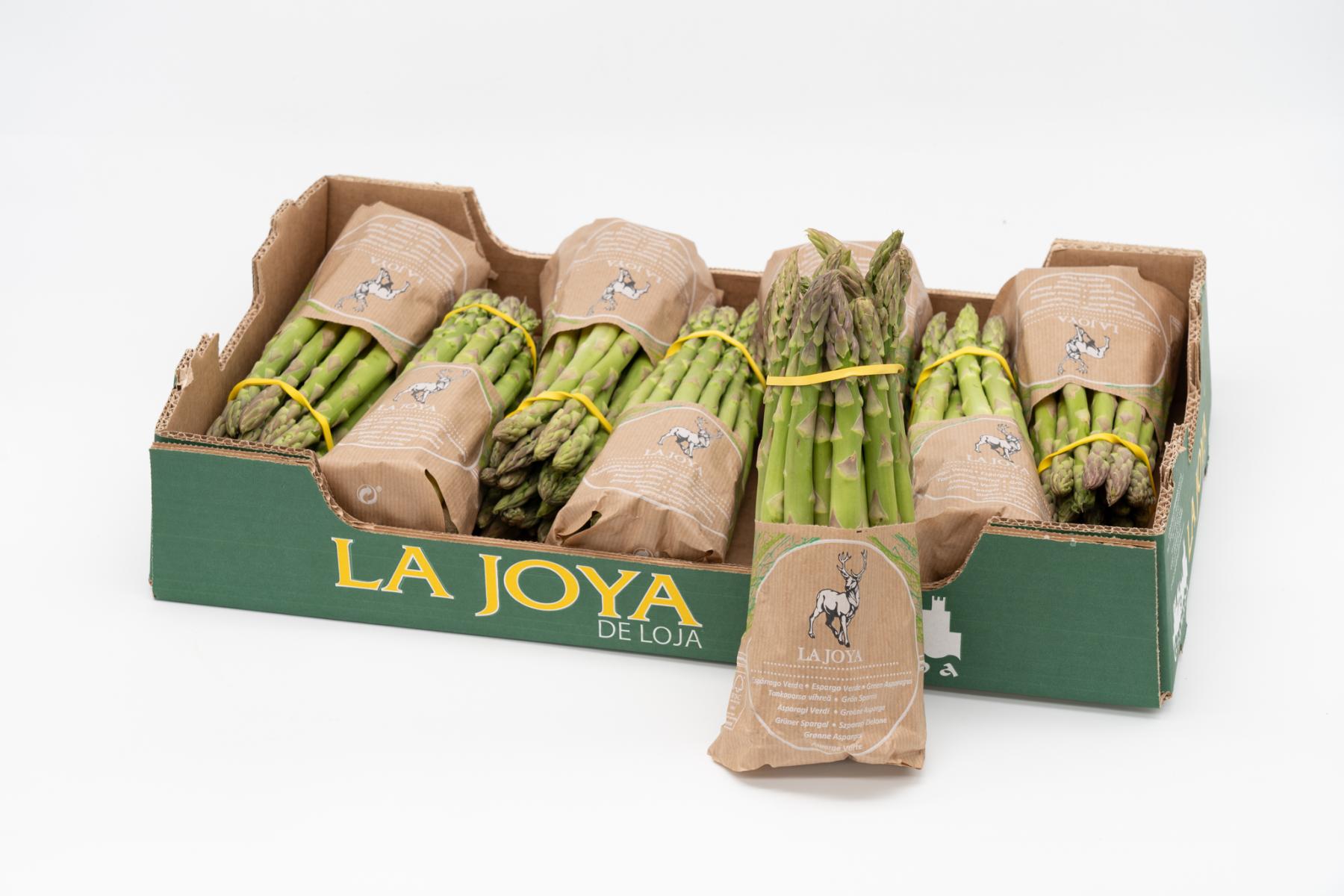 Grünspargel der Marke La Joya in verschiedenen Papierverpackungen und Bündeln in einer grünen Transportkiste.