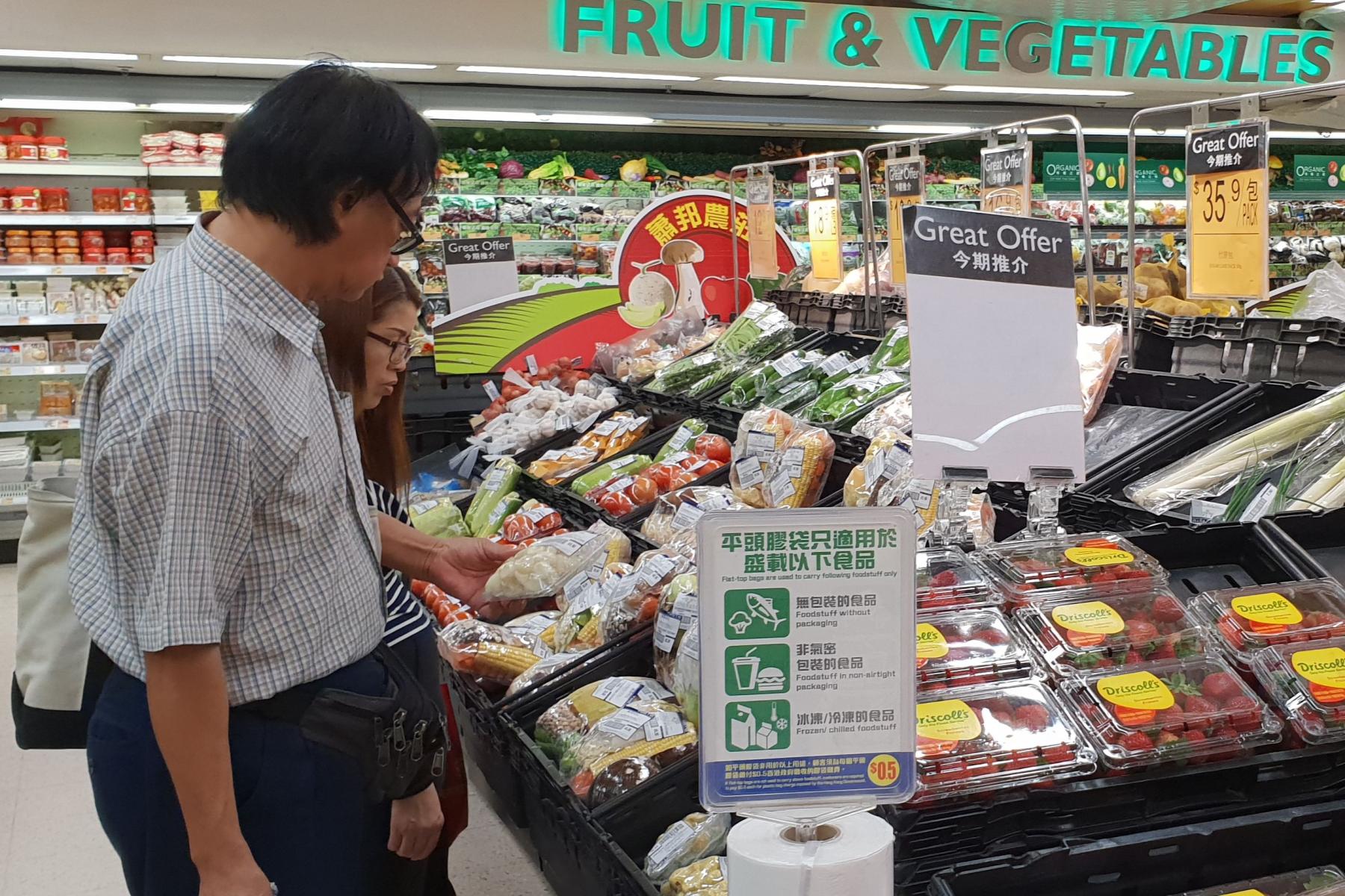 Ein Mann und eine Frau kaufen in einem Supermarkt ein.