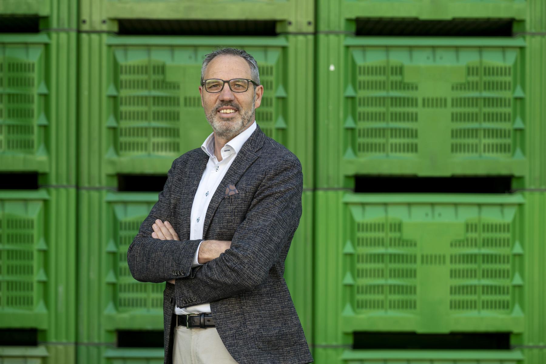 Gerhard Eberhöfer, Bio-Verkaufsleiter bei VIP, vor grünen Apfelkisten