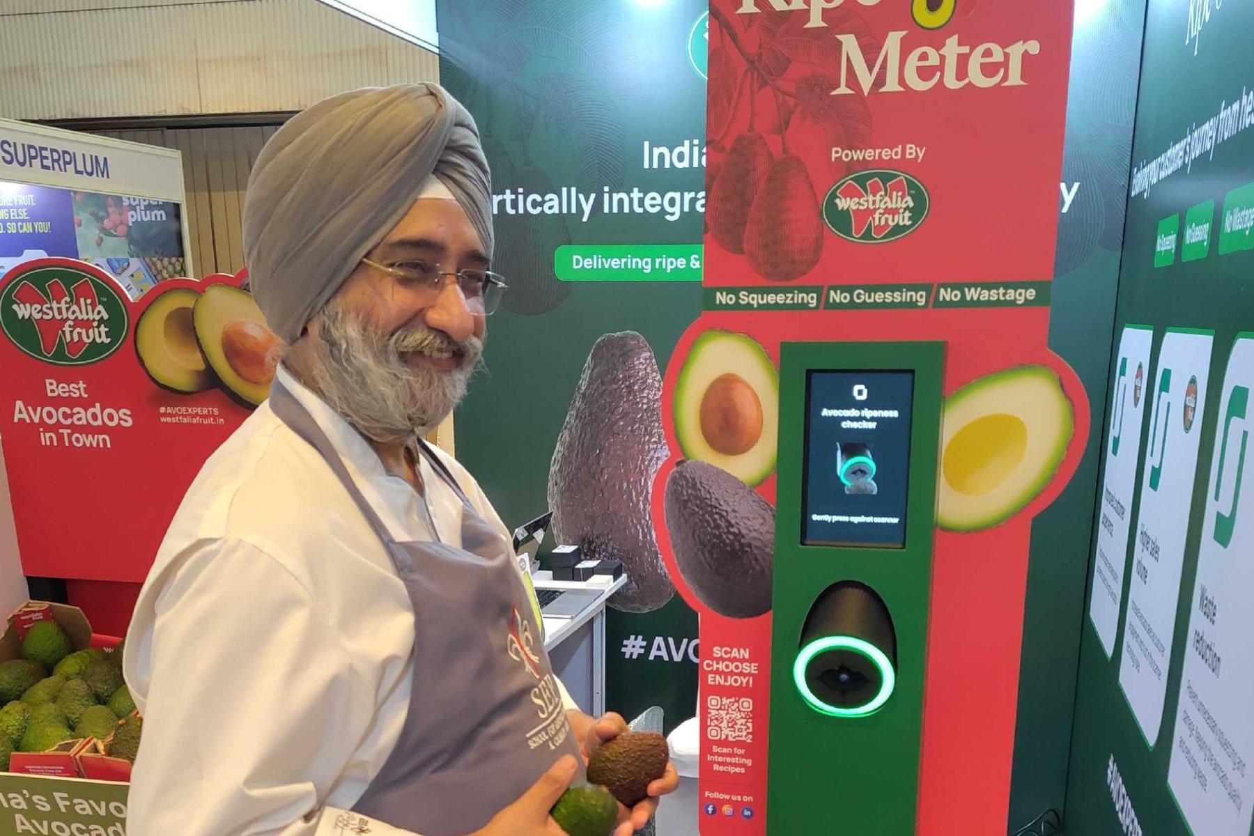 Mann steht mit Avocado vor Automat