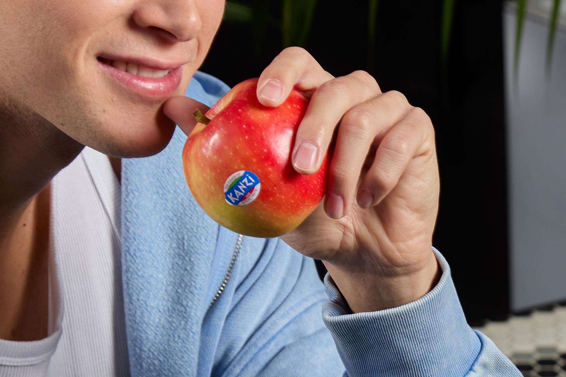 Person mit Kanzi Apfel