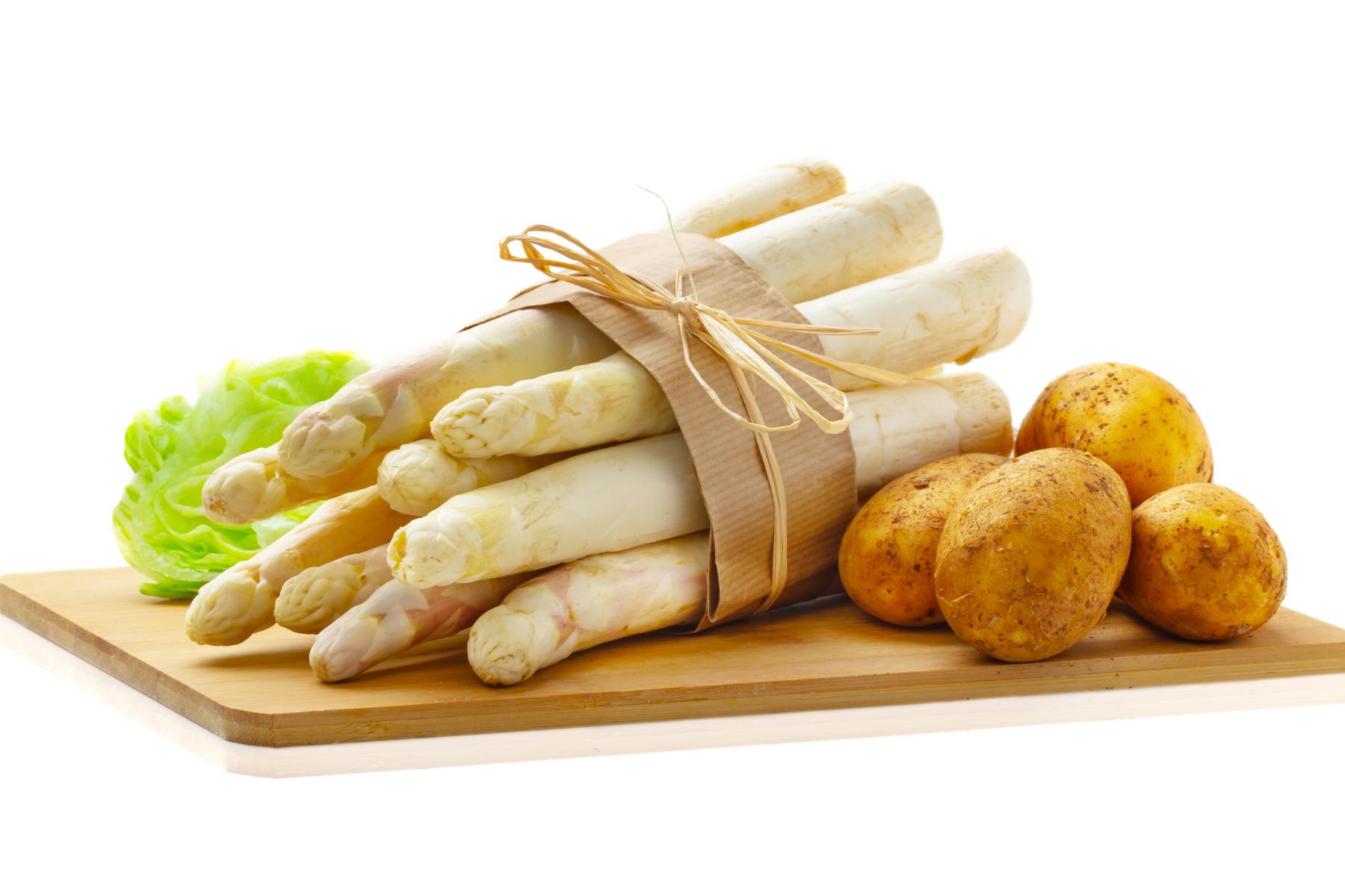 weiße Spargelstangen mit Kartoffeln auf Brett