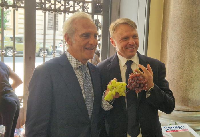 Fruitimprese-Präsident Marco Salvi und Landwirtschaftsminister Francesco Lollobrigida halten je eine Traubenrispe in der Hand