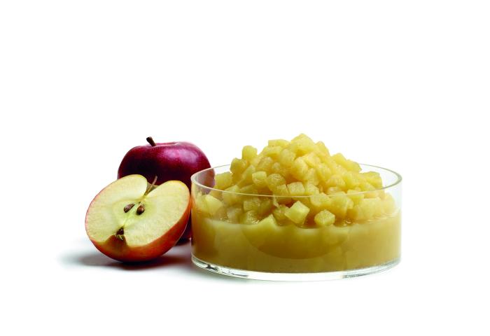 Rote Äpfel, ganz und halbiert, neben einer Glasschale mit Apfelkompott aus gewürfelten Äpfeln