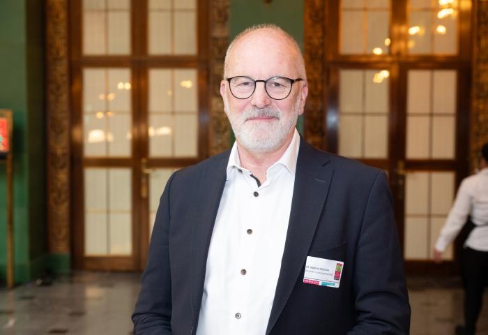 Dr. Andreas Brügger steht in einem Foyer