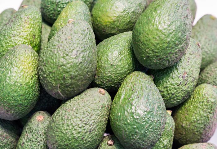 Mehrere grüne Avocados mit rauer, unregelmäßiger Oberfläche dicht aneinandergelegt