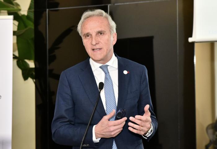 Fruitimprese-Präsident Marco Salvi spricht stehend vor Mikrofon, trägt blauen Anzug und hellblaue Krawatte