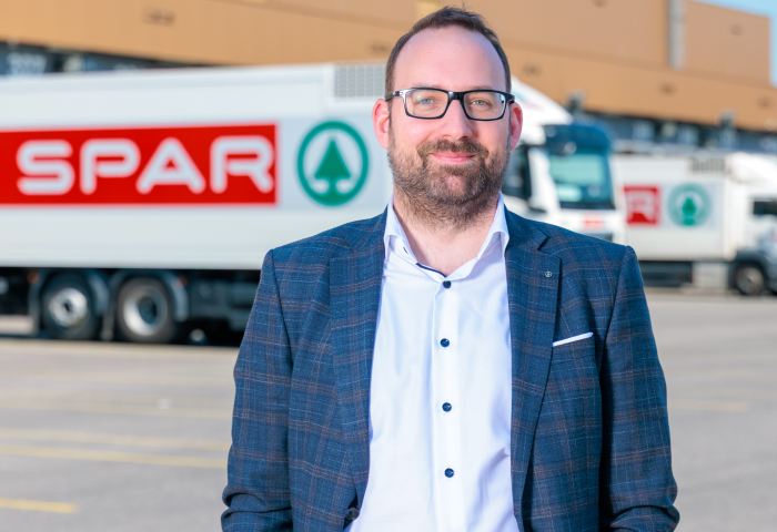 Patrick Hörmann steht vor einem SPAR-LKW auf einem Parkplatz