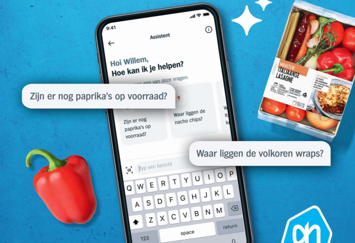 Smartphone zeigt Albert Heijn Assistent mit Fragen zu Paprika und volkoren wraps, daneben rote Paprika und italienische Lasagne Zutatenpackung