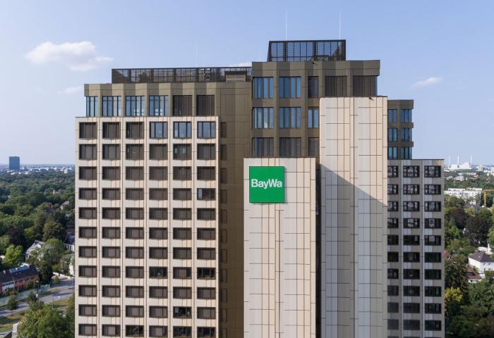 Hauptsitz der BayWa AG, mehrstöckiges Bürogebäude mit grünem BayWa-Logo an der Fassade, umgeben von Bäumen und Stadtlandschaft