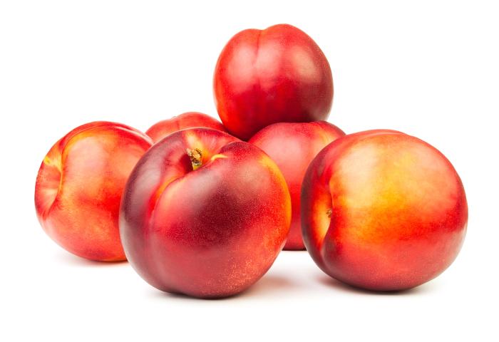 Fünf reife Nektarinen mit roter und gelber Schale auf weißem Hintergrund