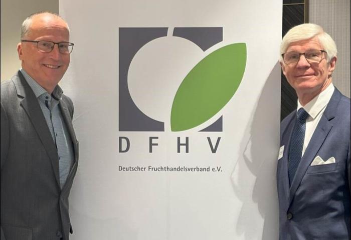Dieter Krauß und Jürgen Bruch stehen neben einem Banner des Deutschen Fruchthandelsverbands e.V. mit einem grünen Blatt und den Buchstaben 'DFHV'.