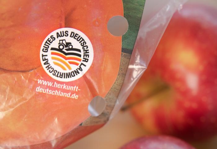 Siegel mit Text 'Gutes aus deutscher Landwirtschaft' und Webseite www.herkunft-deutschland.de auf Verpackung von Obst