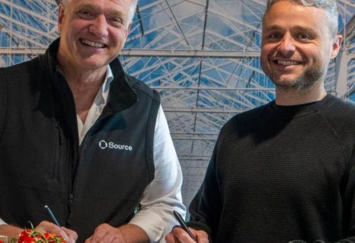 Jelte van Kammen, Generaldirektor von Harvest House, trägt eine schwarze Weste mit Source-Logo, neben Rien Kamman, CEO von Source.ag, in einem Gewächshaus